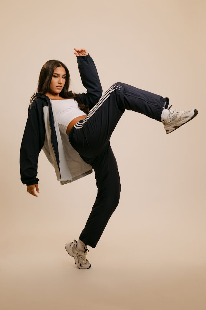 About Confident young woman in sporty attire striking a dynamic pose indoors, perfect for lifestyle themes.