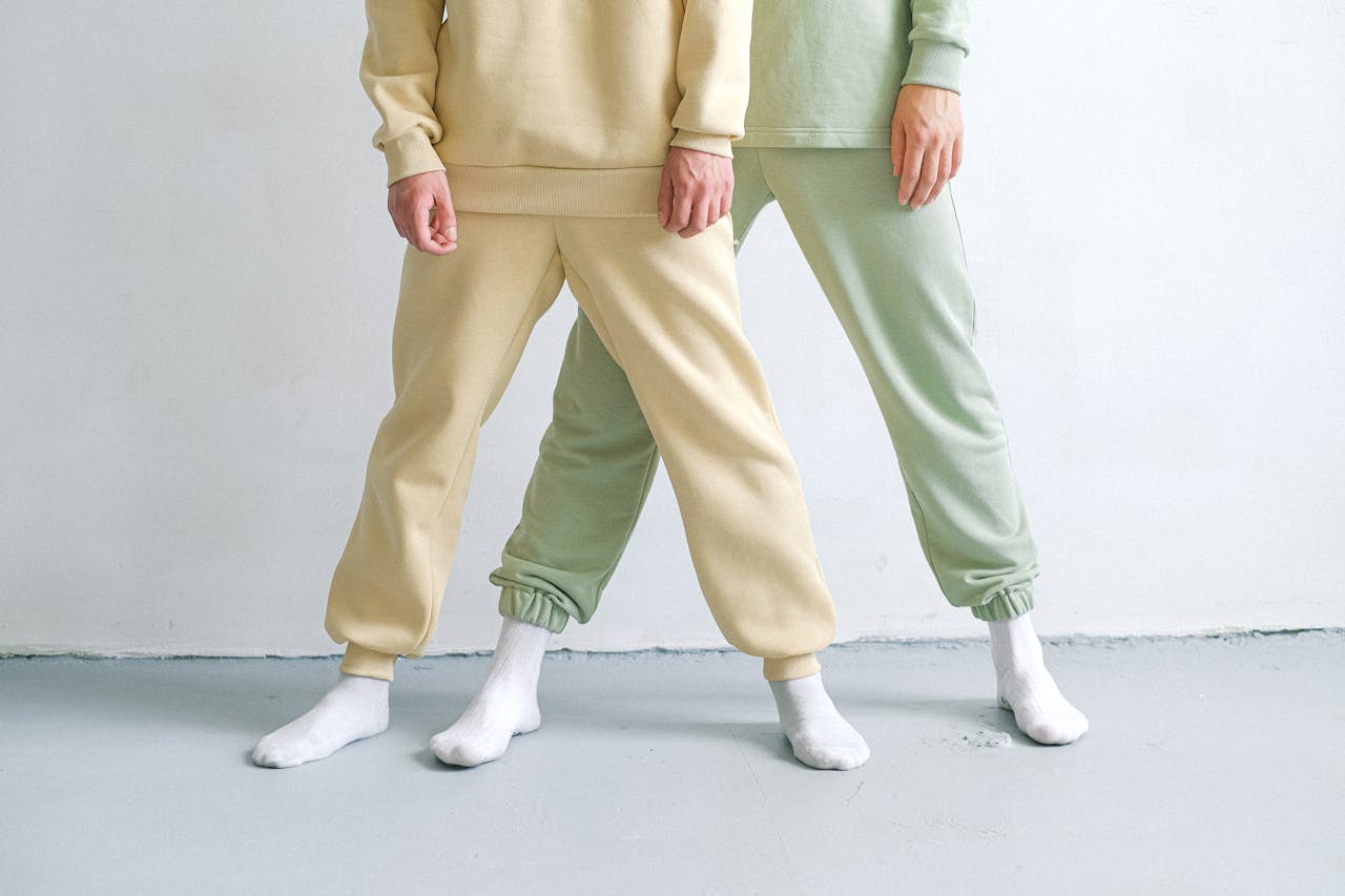 Studio shot showcasing minimalist fashion with two people in tracksuits and socks.